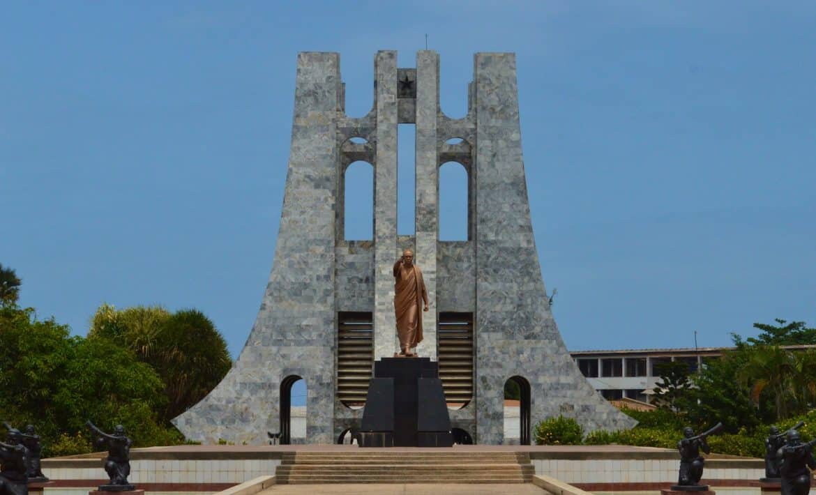 a statue of a person standing in front of a building